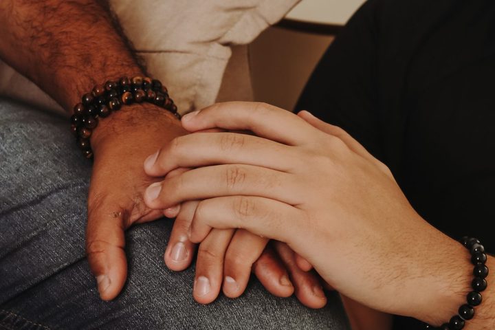 Two hands resting together in a gesture of support